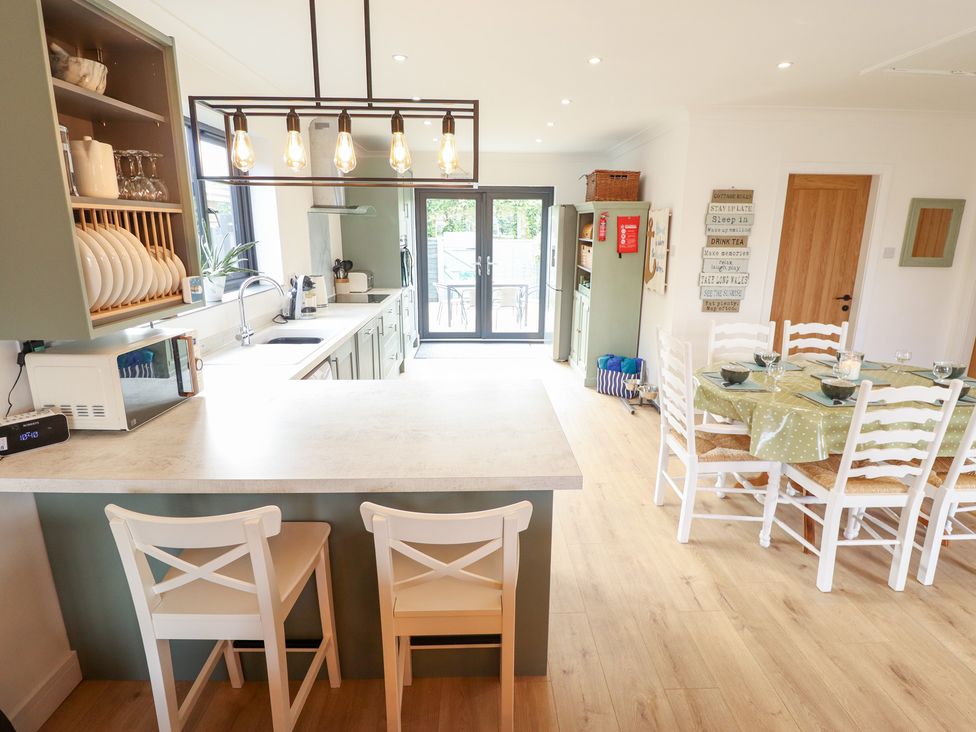 A kitchen with a table and chairs at Sandy Toes in Trusthorpe