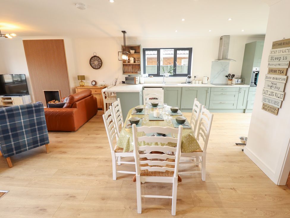 A dining room with a table set for meals at Sandy Toes in Trusthorpe