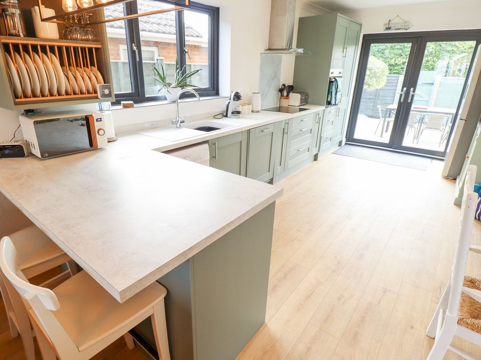 A kitchen with a countertop and seating at Sandy Toes in Trusthorpe