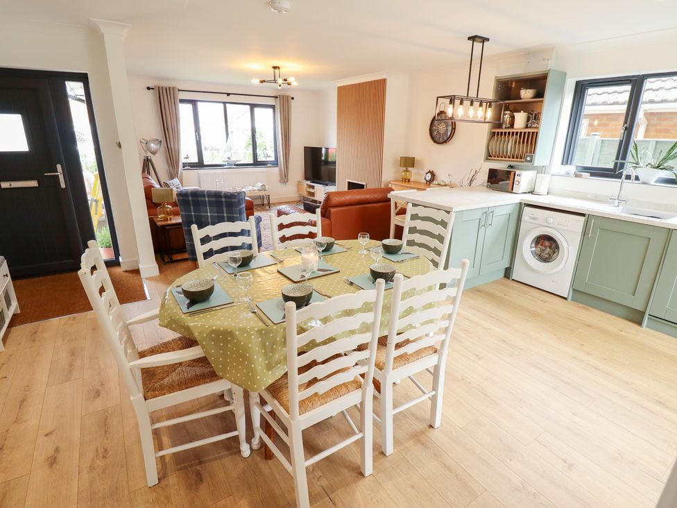 A dining area with a table and chairs at Sandy Toes in Trusthorpe