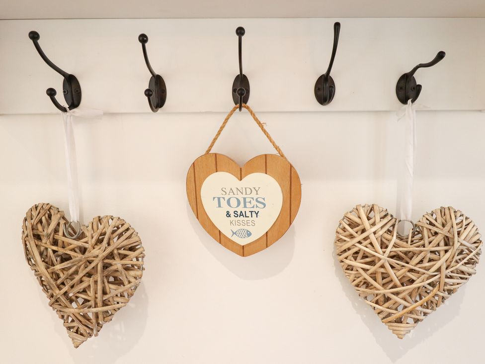 Decorative hearts and a wooden sign in an entryway at Sandy Toes in Trusthorpe