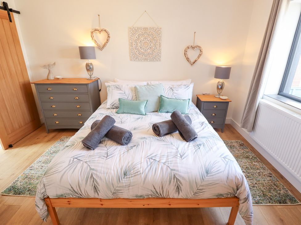 A bedroom with a bed and towels on it at Sandy Toes in Trusthorpe