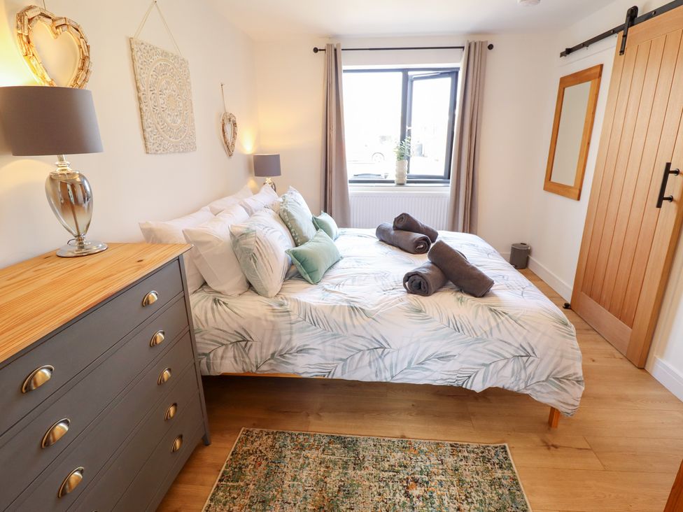 A bedroom with a bed and dresser at Sandy Toes in Trusthorpe