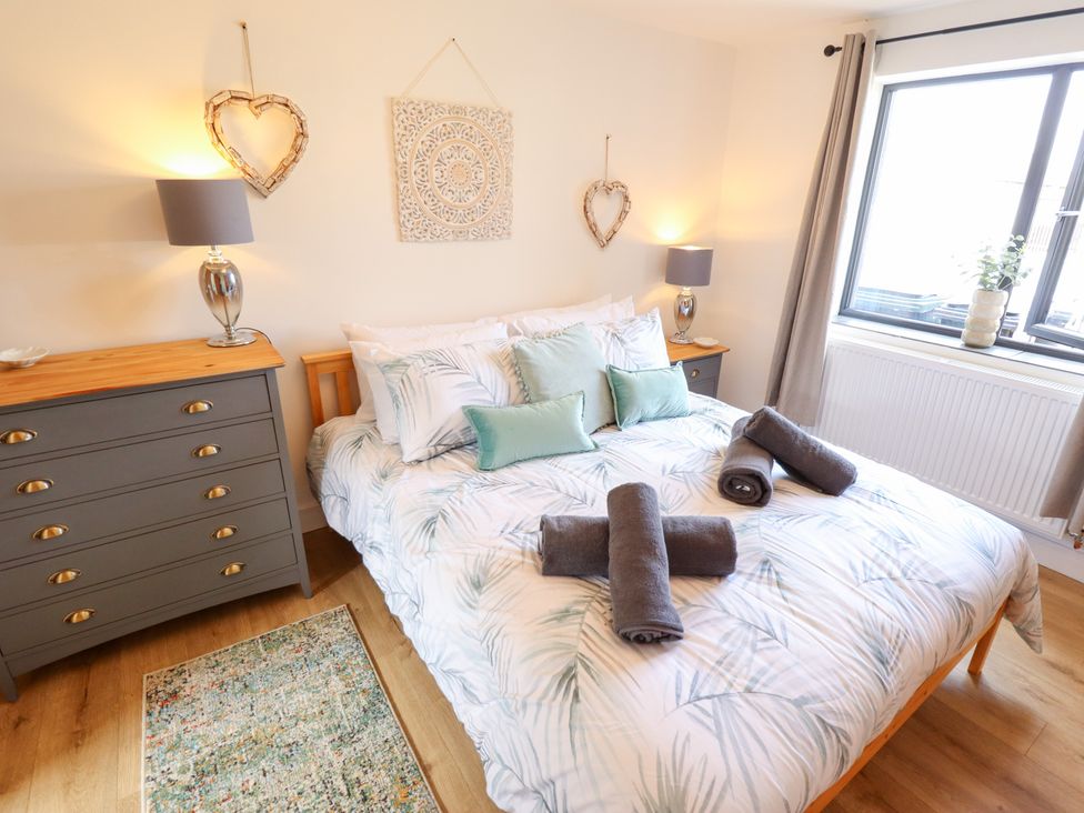 A bedroom with a bed and dresser at Sandy Toes in Trusthorpe