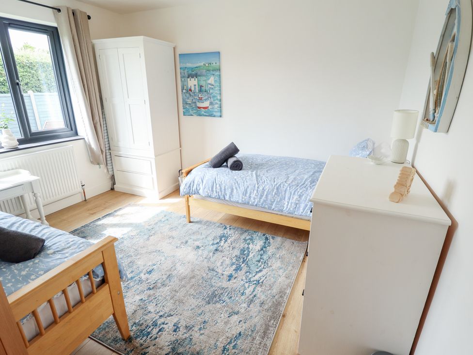 A bedroom with two beds and a wardrobe at Sandy Toes in Trusthorpe