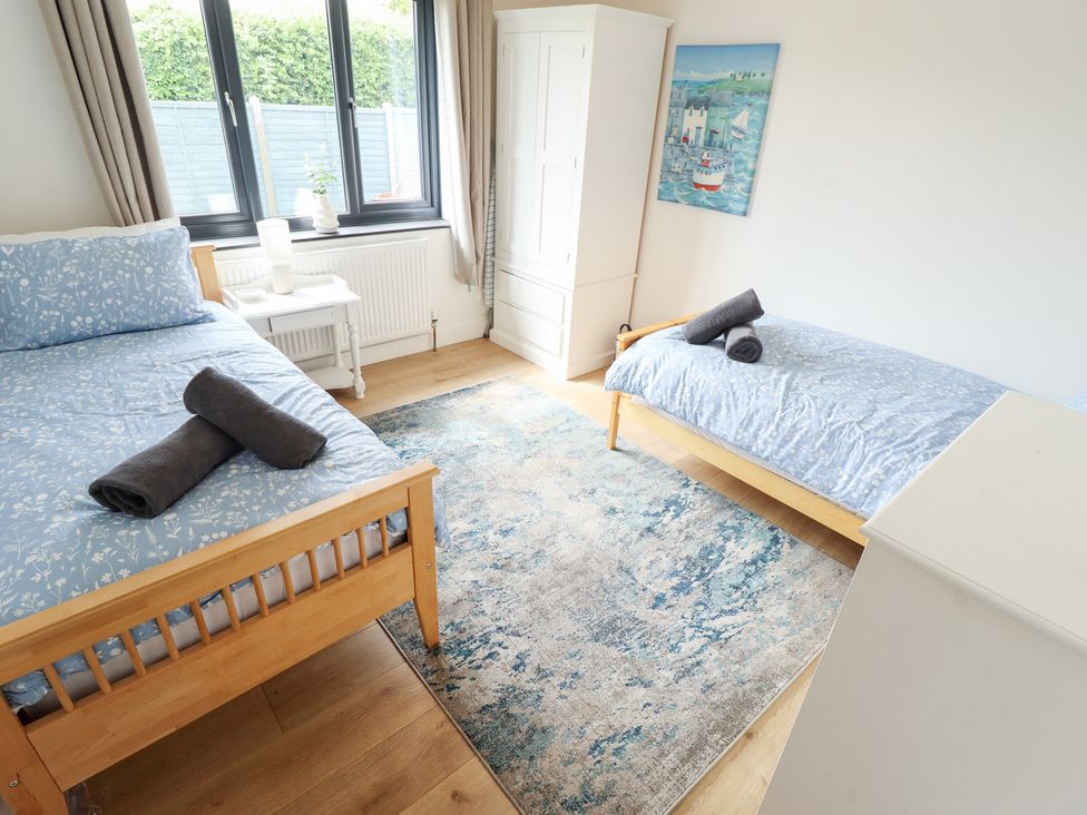 A bedroom with two beds and a wardrobe at Sandy Toes in Trusthorpe