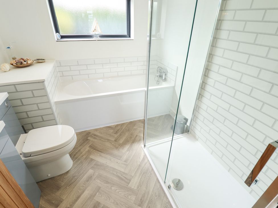 A bathroom with a bathtub, shower, and toilet at Sandy Toes in Trusthorpe