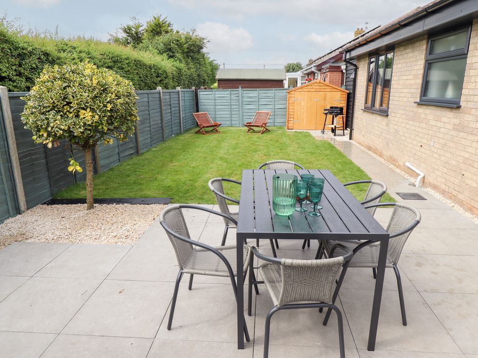 A garden with table and chairs at Sandy Toes in Trusthorpe
