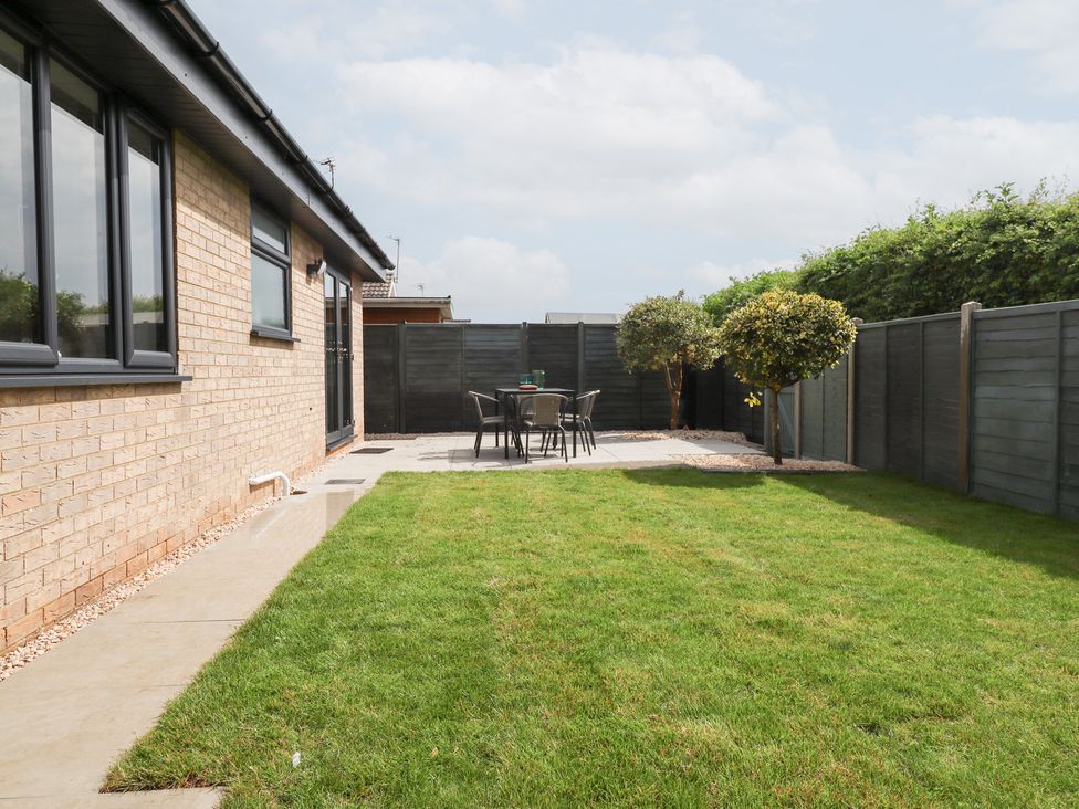 A garden with a patio and seating area at Sandy Toes in Trusthorpe
