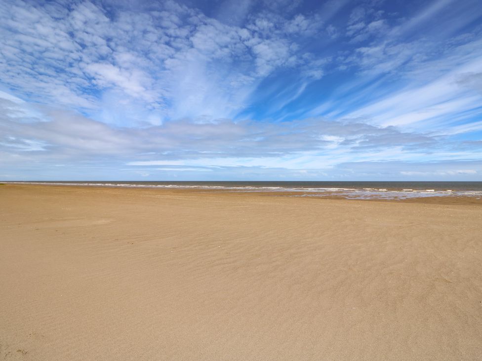 A beach with sand and ocean at Sandy Toes in Sutton-On-Sea