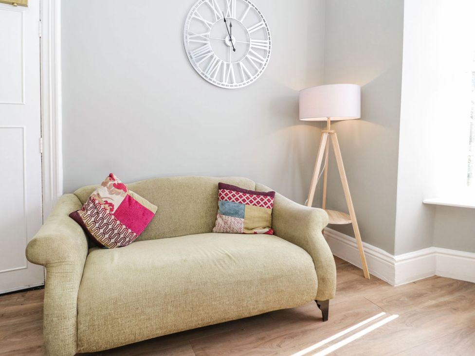 A living room with a sofa and lamp at Flat 1A, Mona House in Conwy