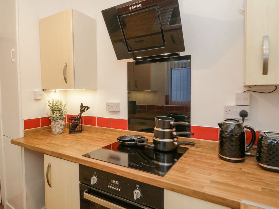 A kitchen with a cooking area and utensils at Flat 1A, Mona House in Conwy