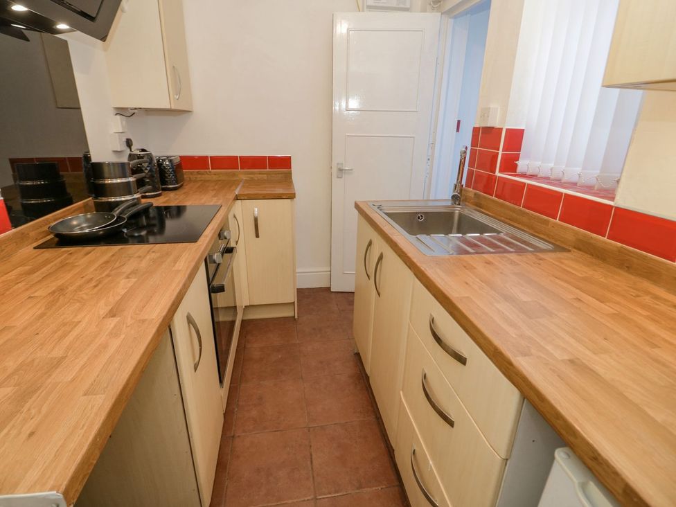 A kitchen with countertops, cabinets, sink and cooking hob at Flat 1A, Mona House in Conwy
