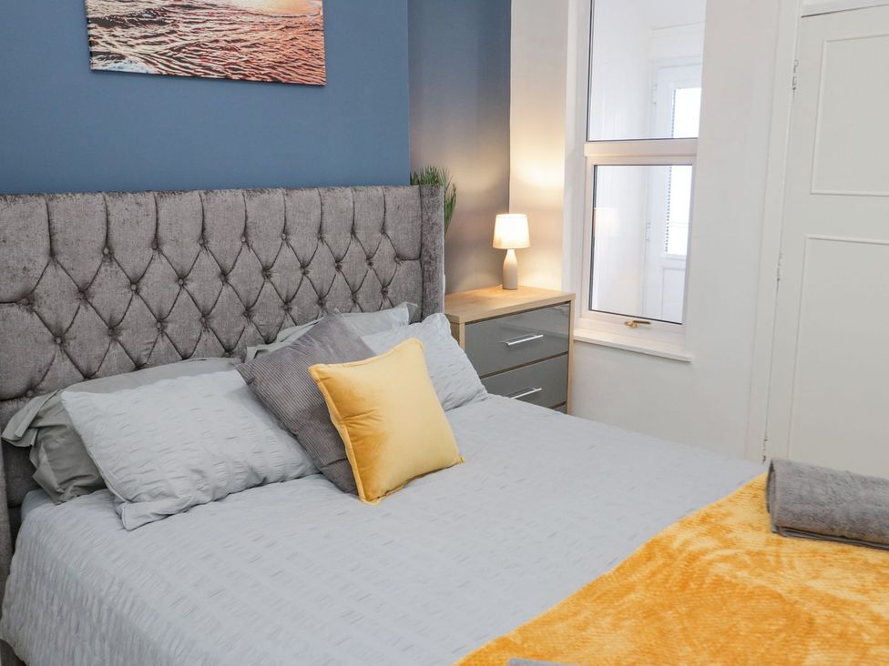 A bedroom with a bed and side table at Flat 1A, Mona House Conwy