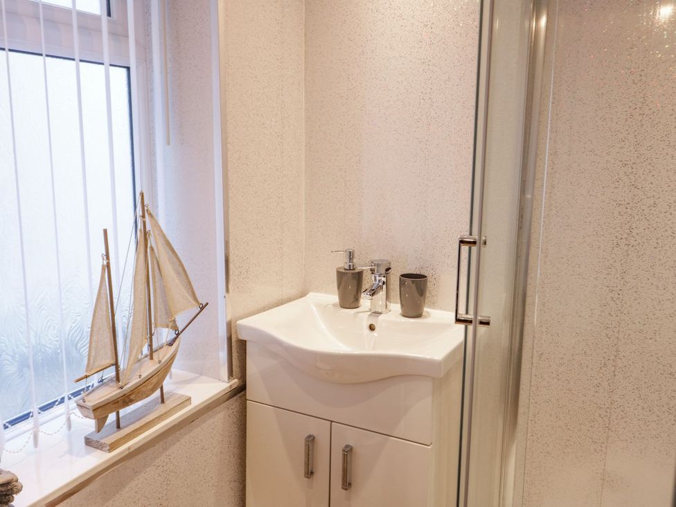 A bathroom with a sink and a shower at Flat 1A, Mona House in Conwy