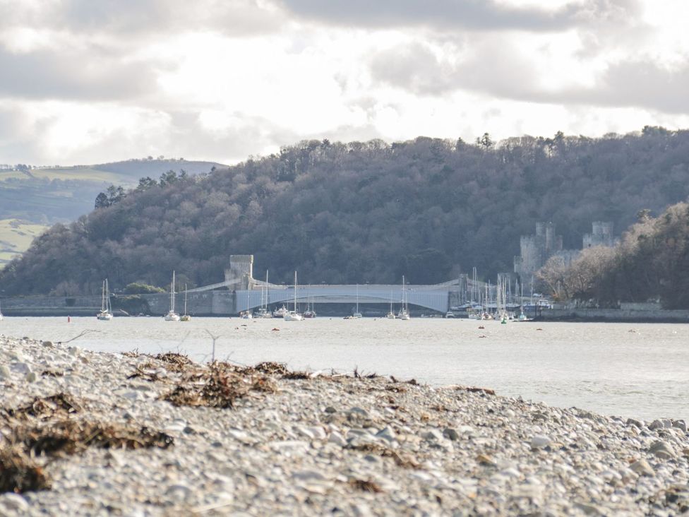 A view of a river with boats and a bridge at Flat 1A, Mona House in Conwy