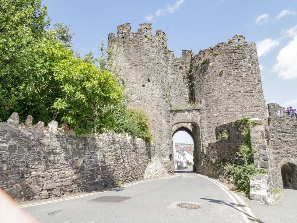 A stone castle with an archway and trees at Flat 1A, Mona House in Conwy