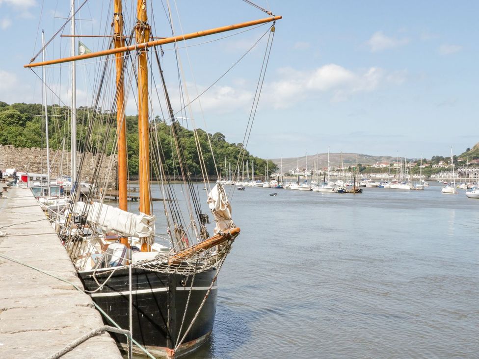 A boat docked at a harbor with hills in the background at Flat 1A, Mona House in Conwy