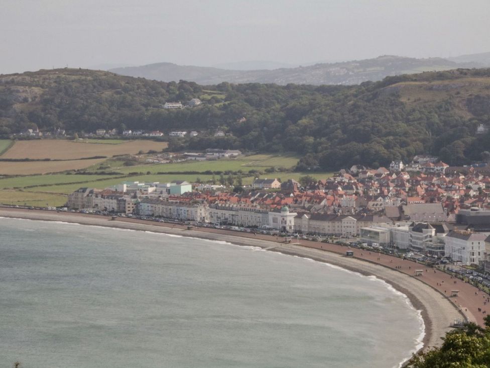 A view of a coastline with buildings along the shore at Flat 1A, Mona House in Conwy