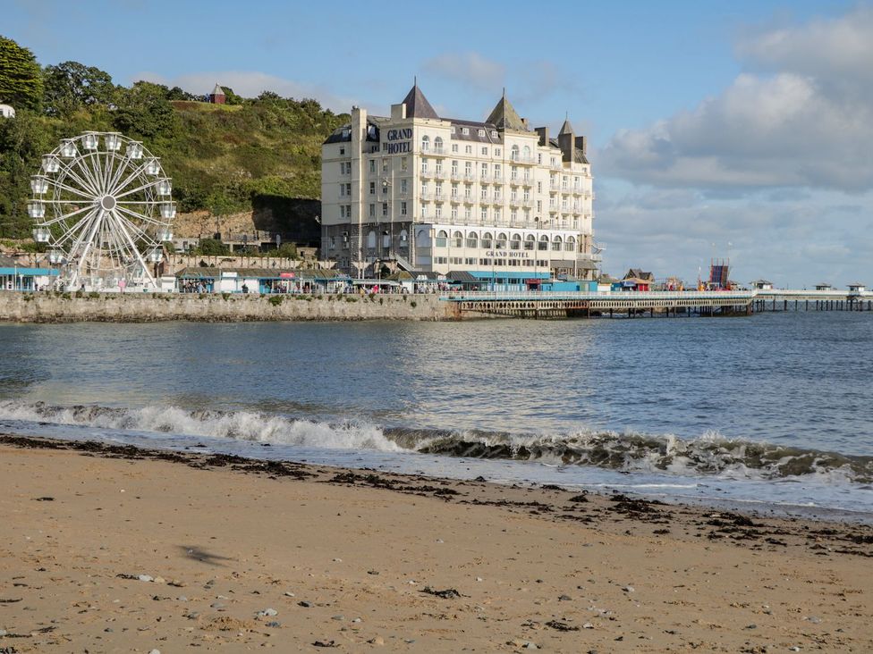 A beach with a hotel and ferris wheel at Flat 1A, Mona House Conwy