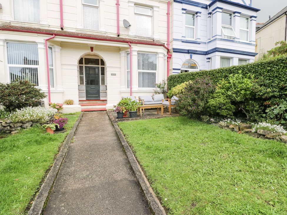 A garden with a pathway and seating area at Flat 1, Mona House in Conwy