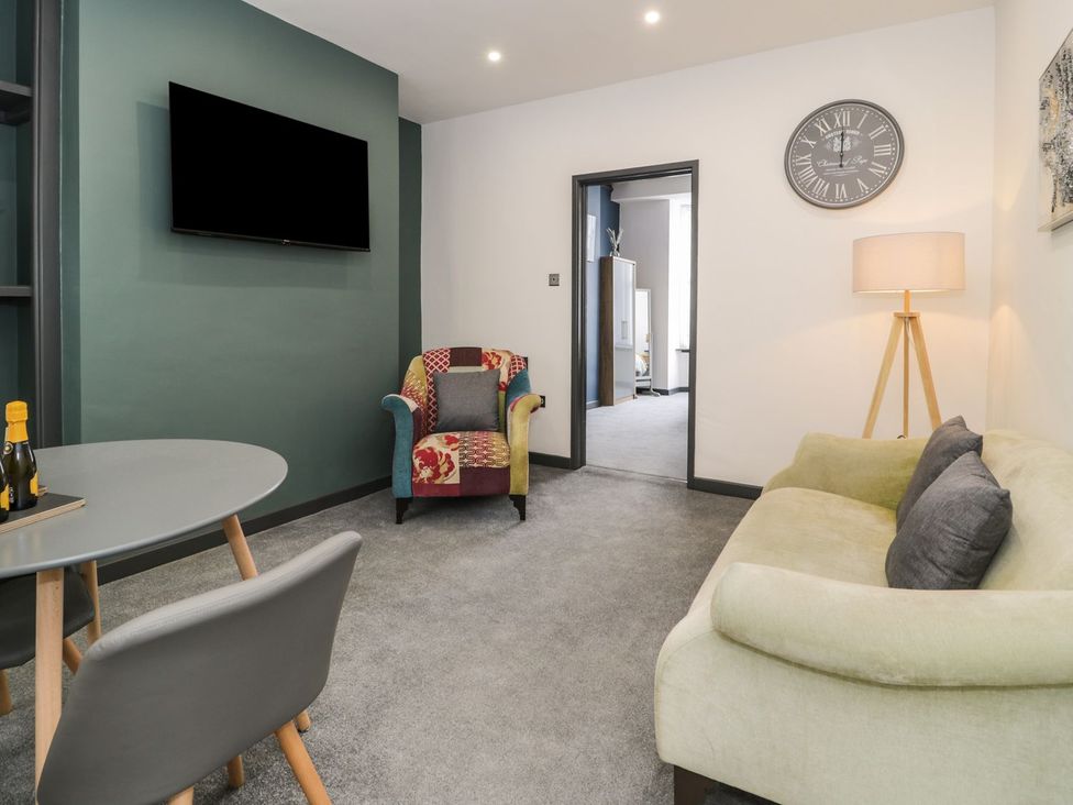 A living room with a television and armchair at Flat 1, Mona House in Conwy