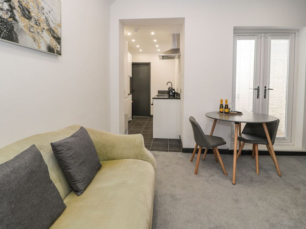 A living room with a sofa and dining table at Flat 1, Mona House in Conwy