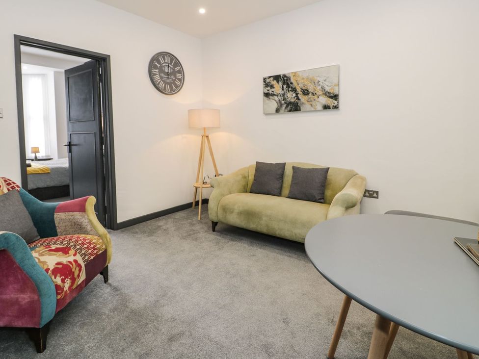 A living room with a sofa and armchair at Flat 1, Mona House Conwy