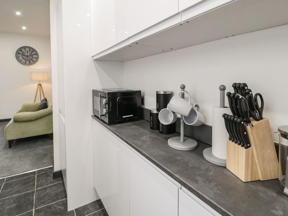 A kitchen with microwave and kitchen utensils at Flat 1, Mona House in Conwy