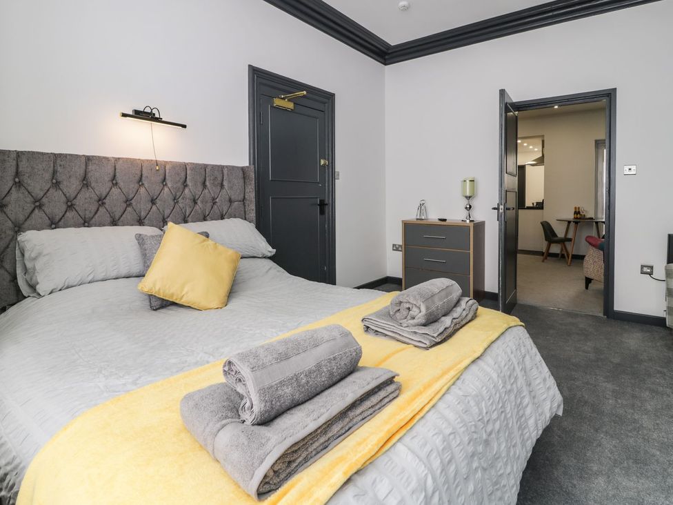 A bedroom with a bed and nightstand at Flat 1, Mona House Conwy
