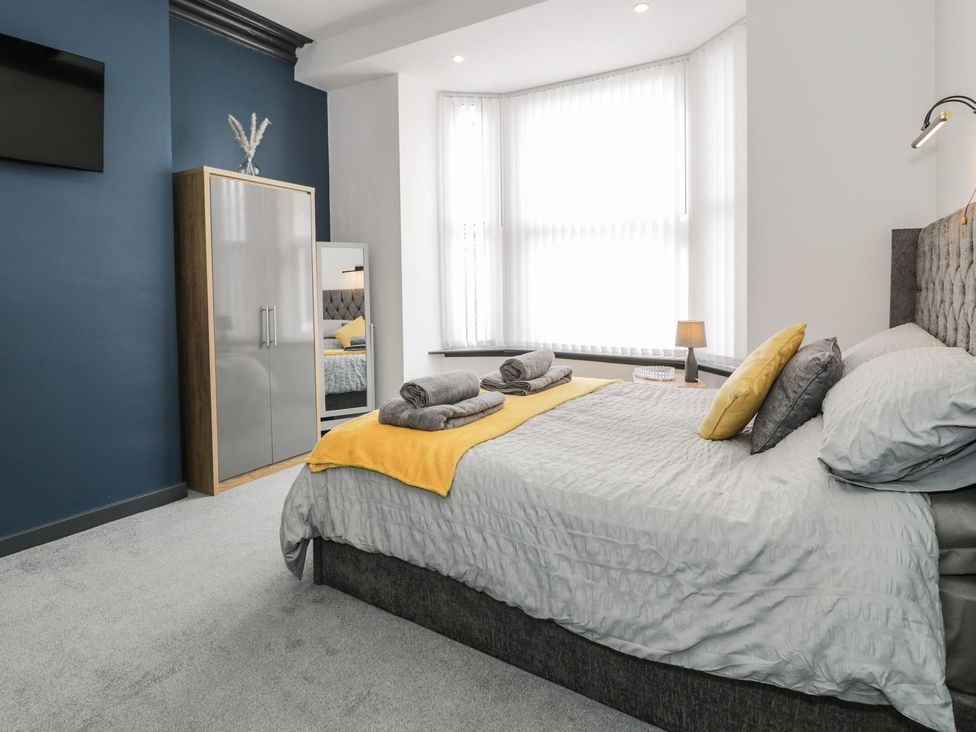 A bedroom with a bed and wardrobe at Flat 1, Mona House in Conwy