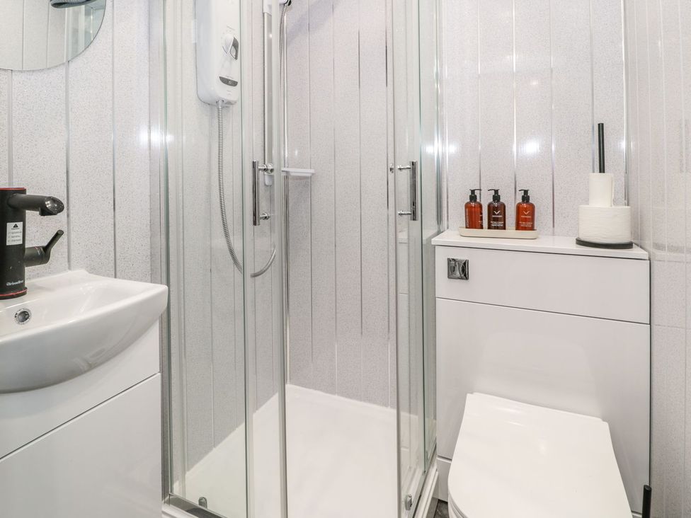 A bathroom with shower, sink, and toilet at Flat 1, Mona House, Conwy