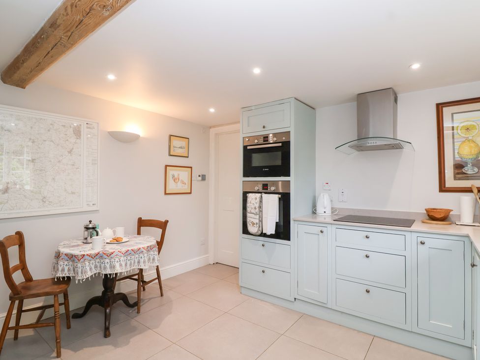 A kitchen with a table and chairs at Magdalen Cottage in Hook Norton