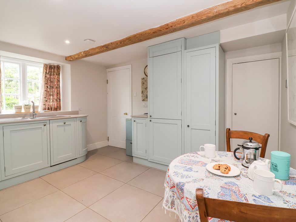 A kitchen with a table and chairs at Magdalen Cottage in Hook Norton