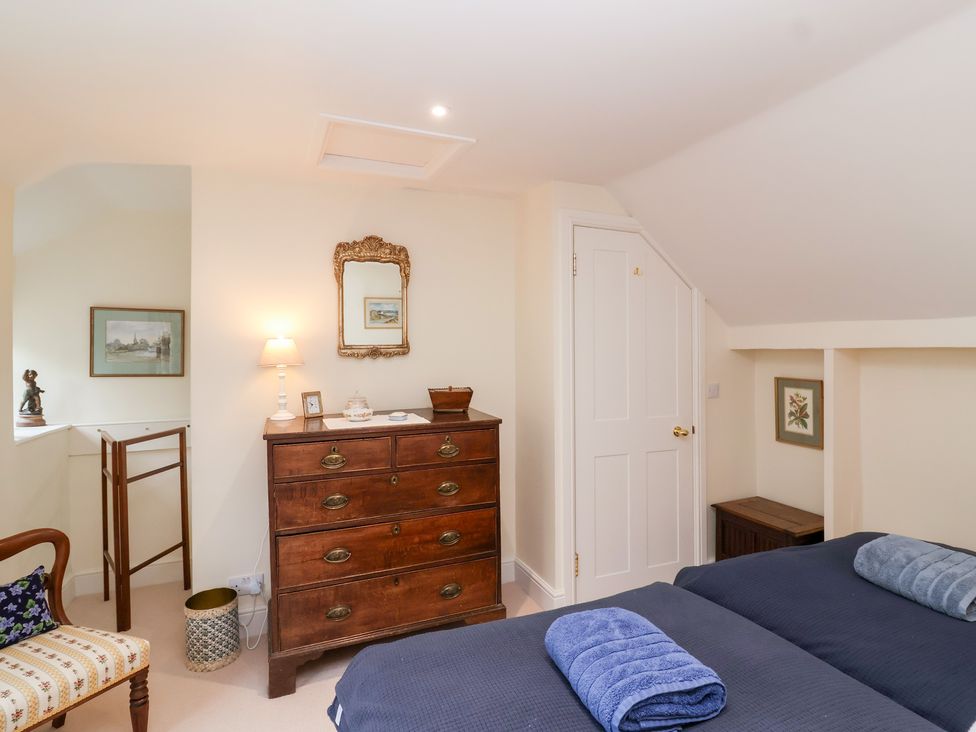 A bedroom with a bed and chest of drawers at Magdalen Cottage in Hook Norton