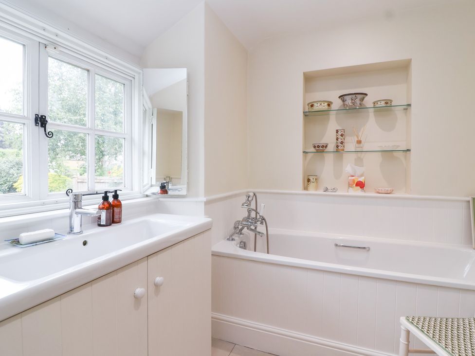 A bathroom with a bathtub and sink at Magdalen Cottage in Hook Norton