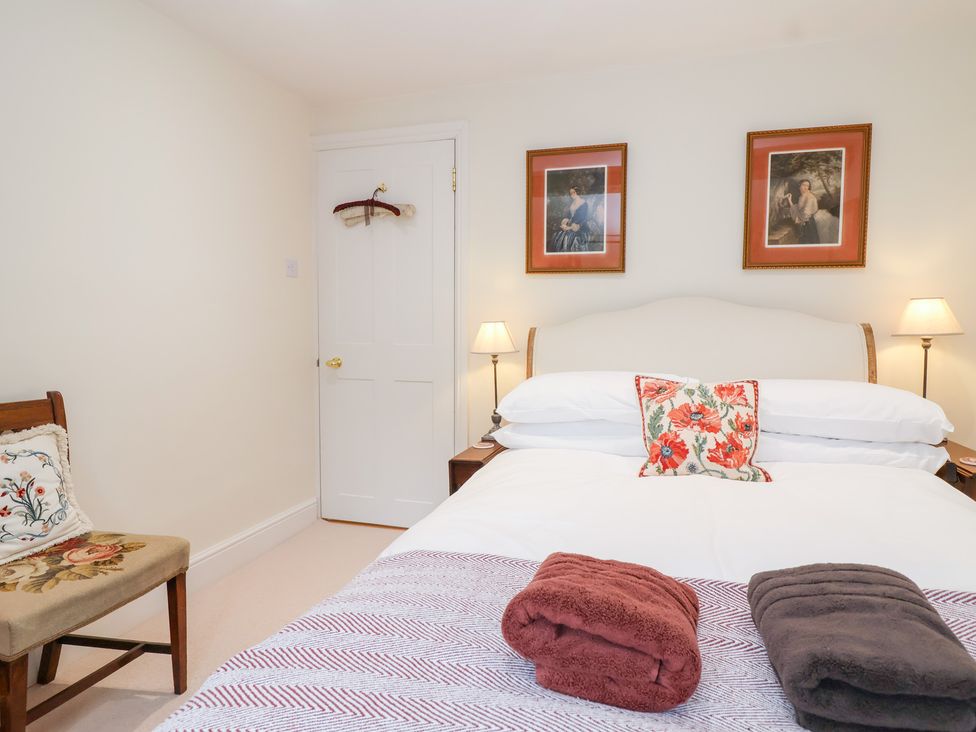 A bedroom with a bed and two bedside lamps at Magdalen Cottage in Hook Norton