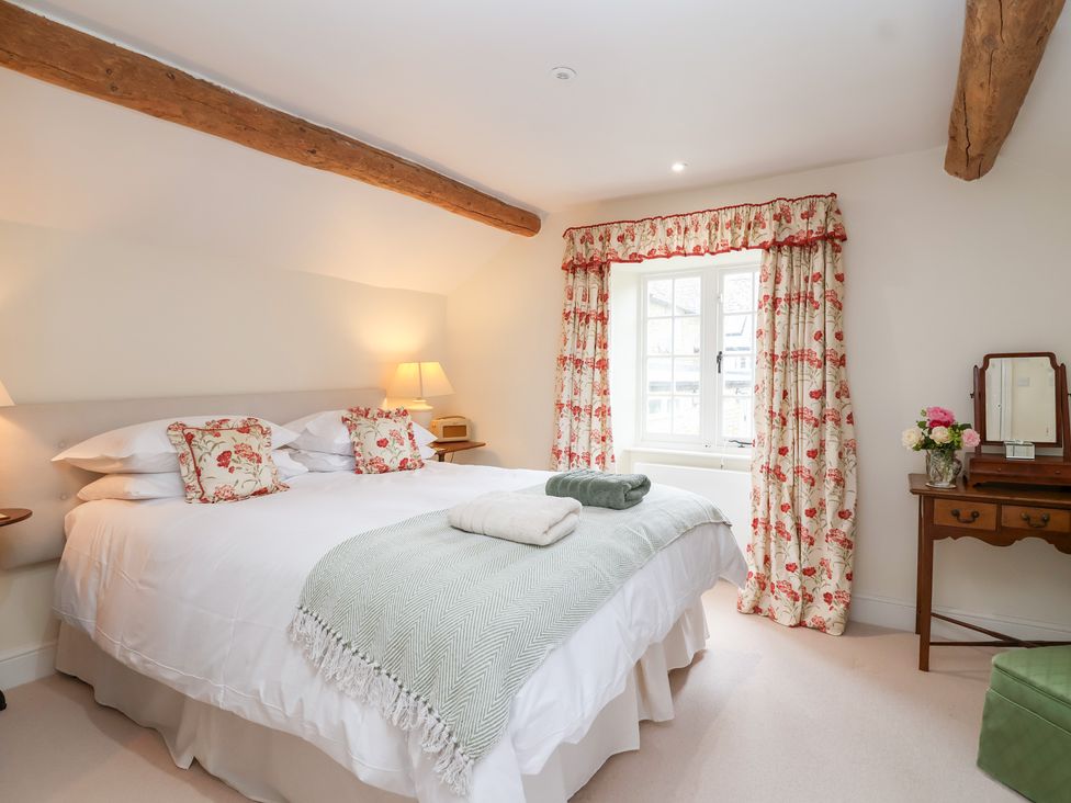 A bedroom with a double bed and a dresser at Magdalen Cottage in Hook Norton