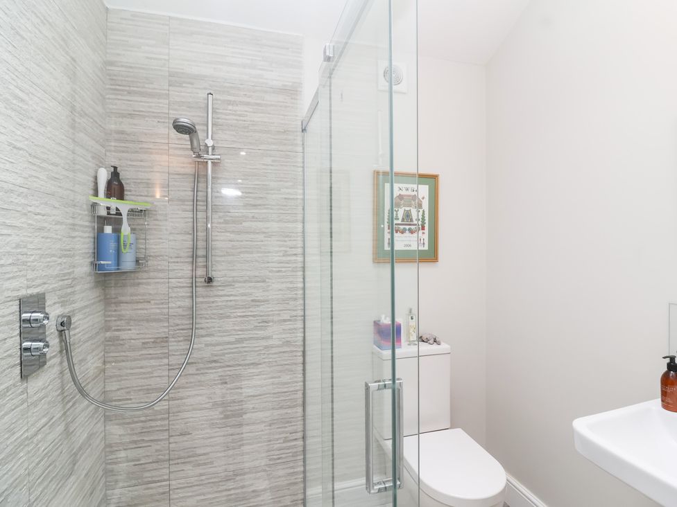 A bathroom with a shower, toilet, and sink at Magdalen Cottage in Hook Norton