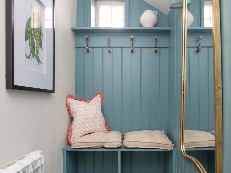 An entryway with wall hooks and cushions at Apartment 1, 86 Dyer Street Cirencester