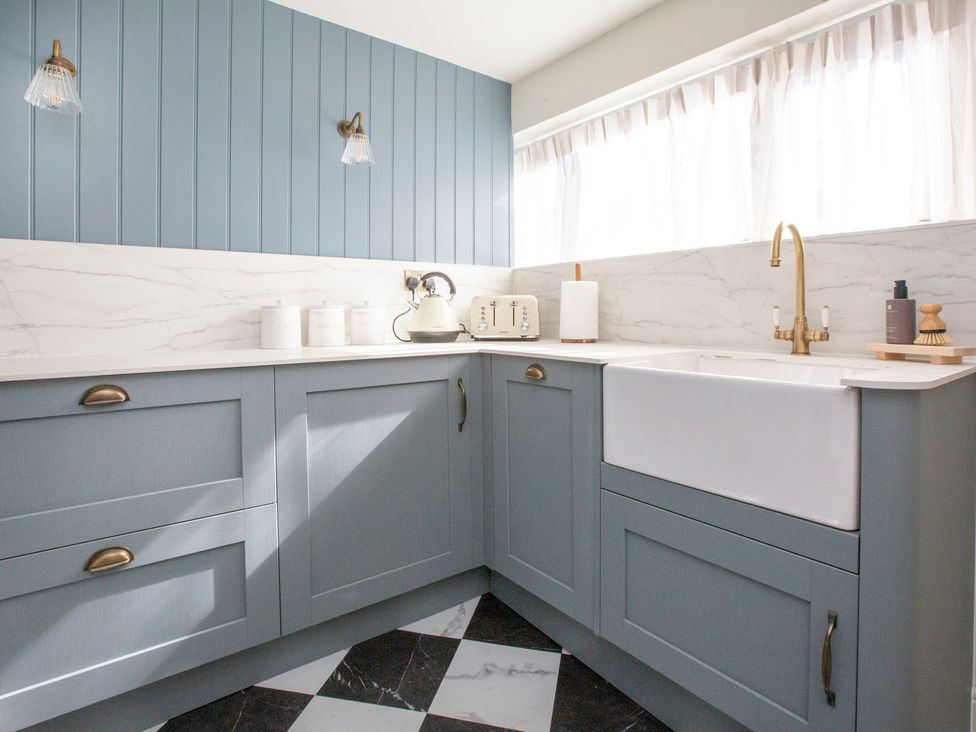 A kitchen with a sink, cabinets and appliances at Apartment 1, 86 Dyer Street Cirencester