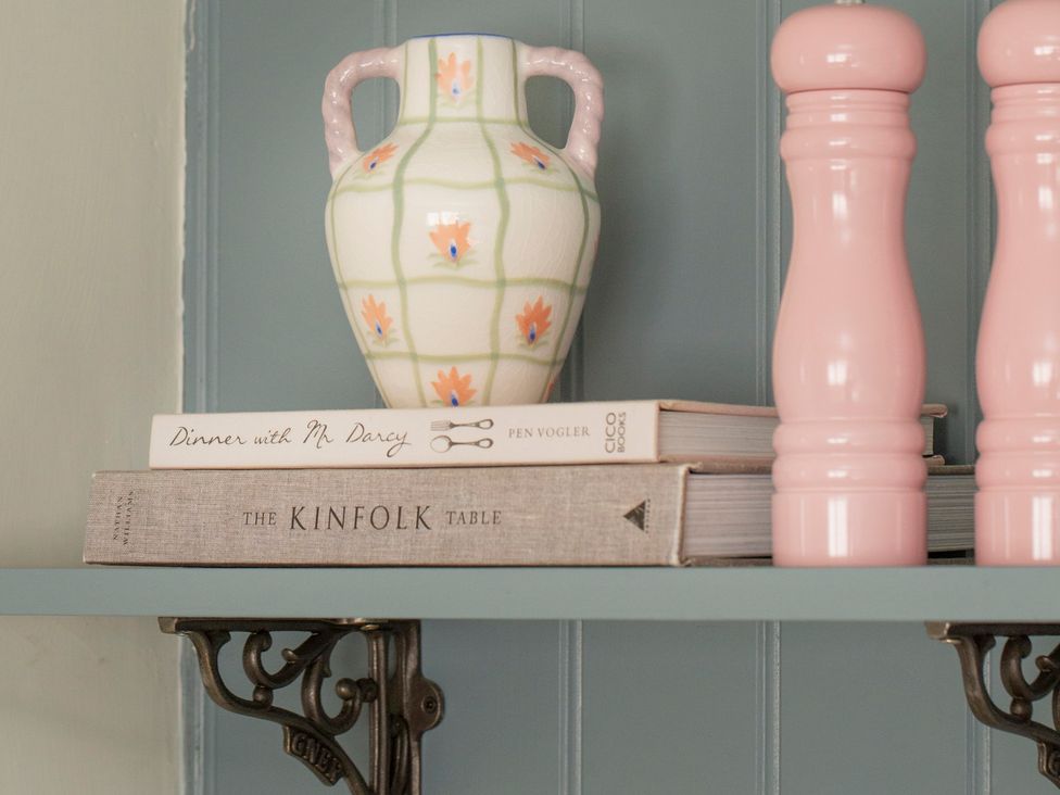 A shelf with a vase, books and salt and pepper shakers at Apartment 1, 86 Dyer Street Cirencester