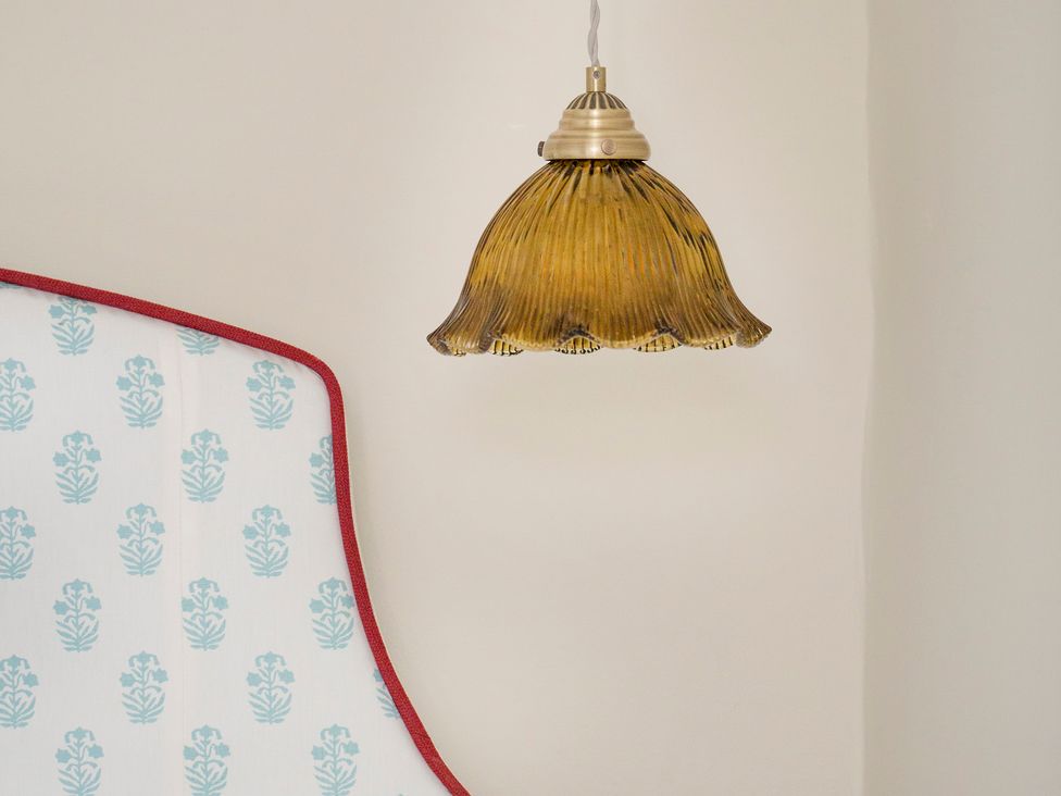 A lamp hanging above a bed in Apartment 1, 86 Dyer Street Cirencester