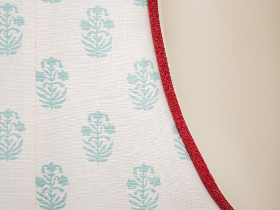 A fabric with a blue pattern and red trim