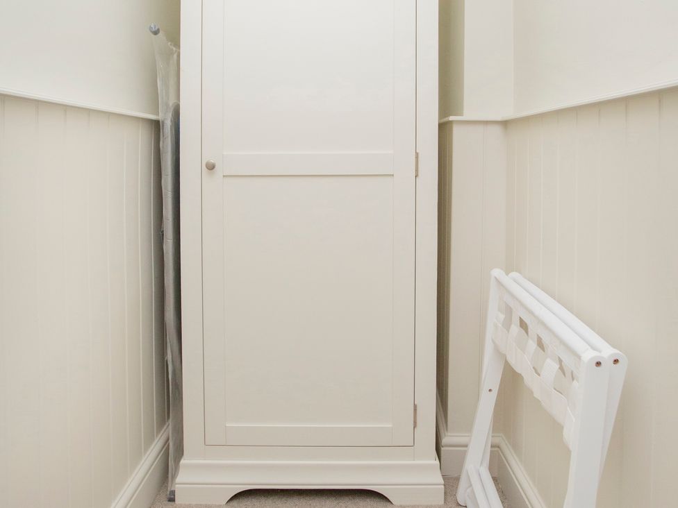 A wardrobe and an umbrella in a hallway at Apartment 1, 86 Dyer Street Cirencester