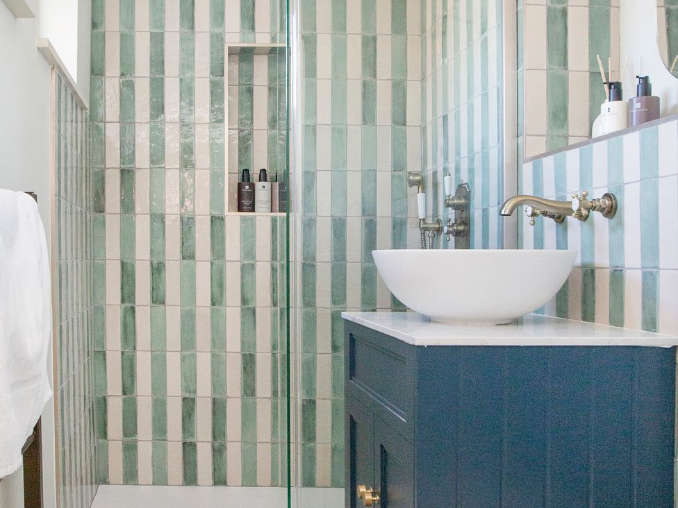 A bathroom with a shower and sink at Apartment 1, 86 Dyer Street, Cirencester