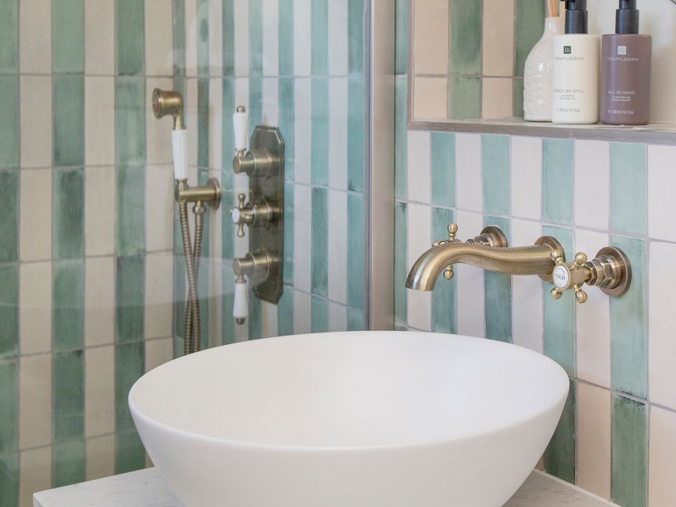 A bathroom with a sink and shower at Apartment 1, 86 Dyer Street Cirencester