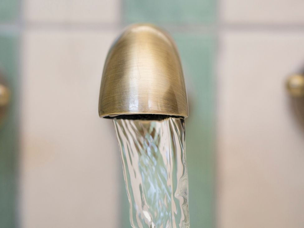 A faucet with flowing water at Apartment 1, 86 Dyer Street Cirencester