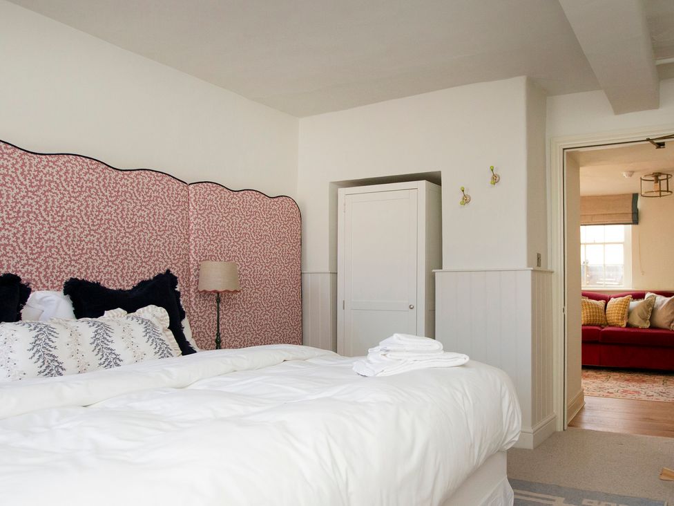 A bedroom with a bed and wardrobe at Apartment 1, 86 Dyer Street in Cirencester