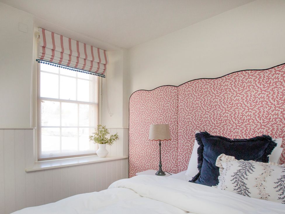 A bedroom with a bed and decorative pillows at Apartment 1, 86 Dyer Street Cirencester